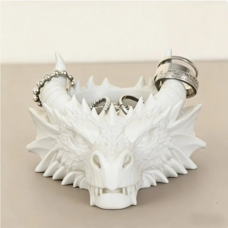 Tête de dragon en résine blanche pour bureau, avec dents acérées et un anneau argenté.