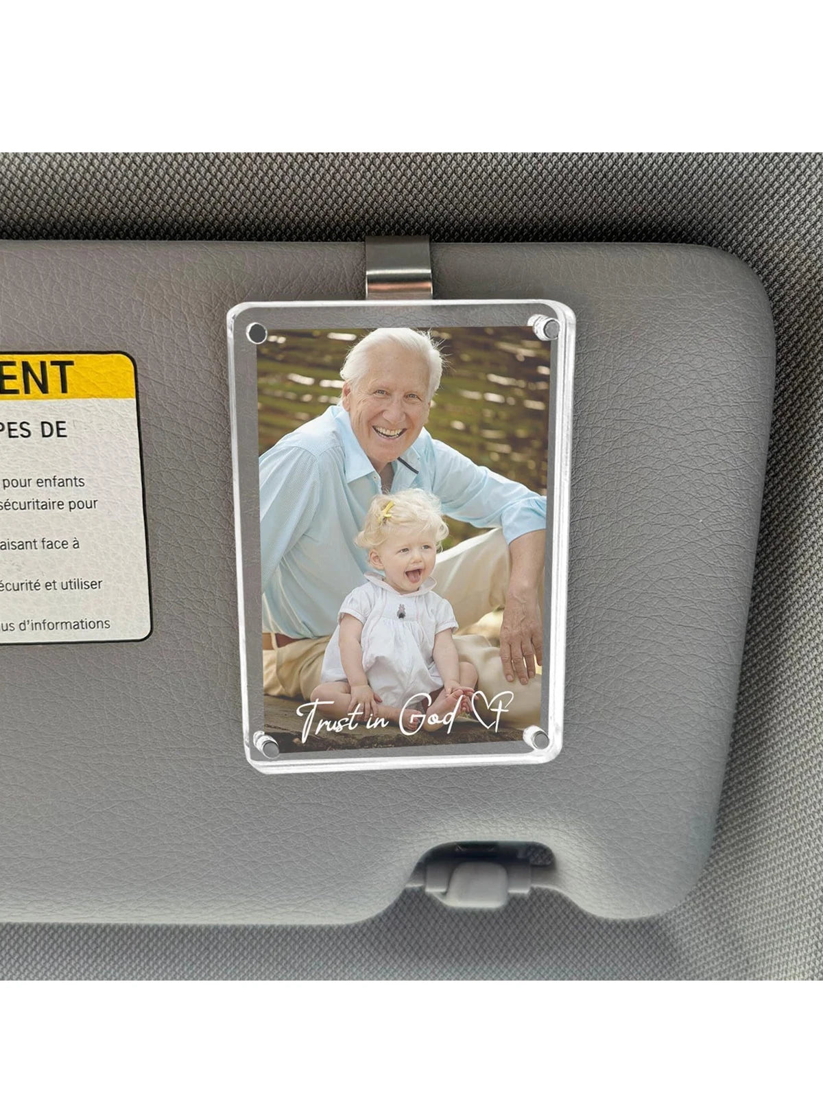 A clear acrylic photo clip featuring a portrait of an elderly man smiling, mounted in a car sun visor.