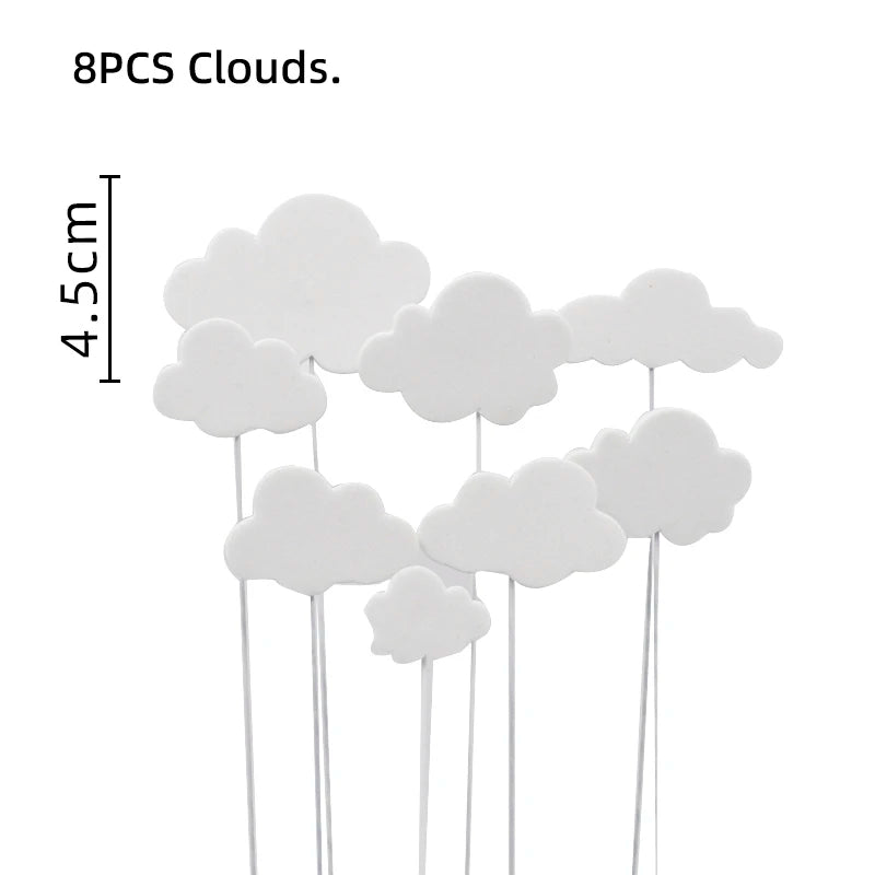 Eight white cloud-shaped cake toppers on sticks for a birthday party decoration