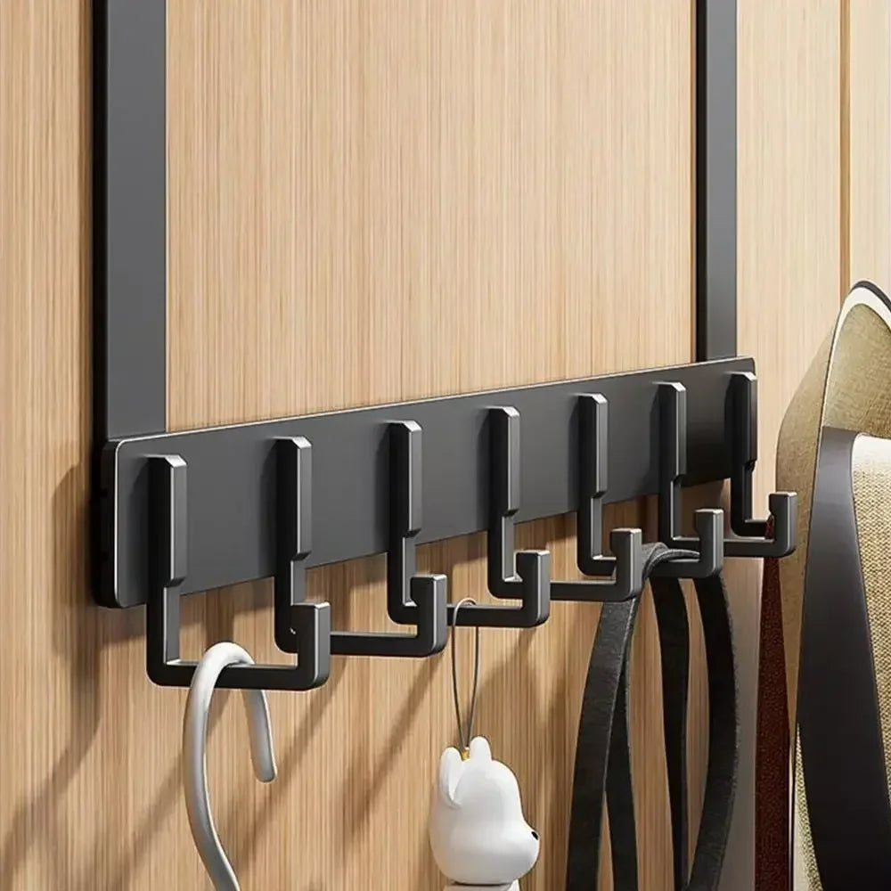 A black heavy duty aluminum door hook rack mounted on a wooden wall, with several hooks for hanging items.