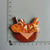 A set of playful food-shaped fridge magnets featuring various sliced fruits and vegetables in an orange bowl.