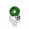 A white birthday candle decorated with a green glitter soccer ball design.