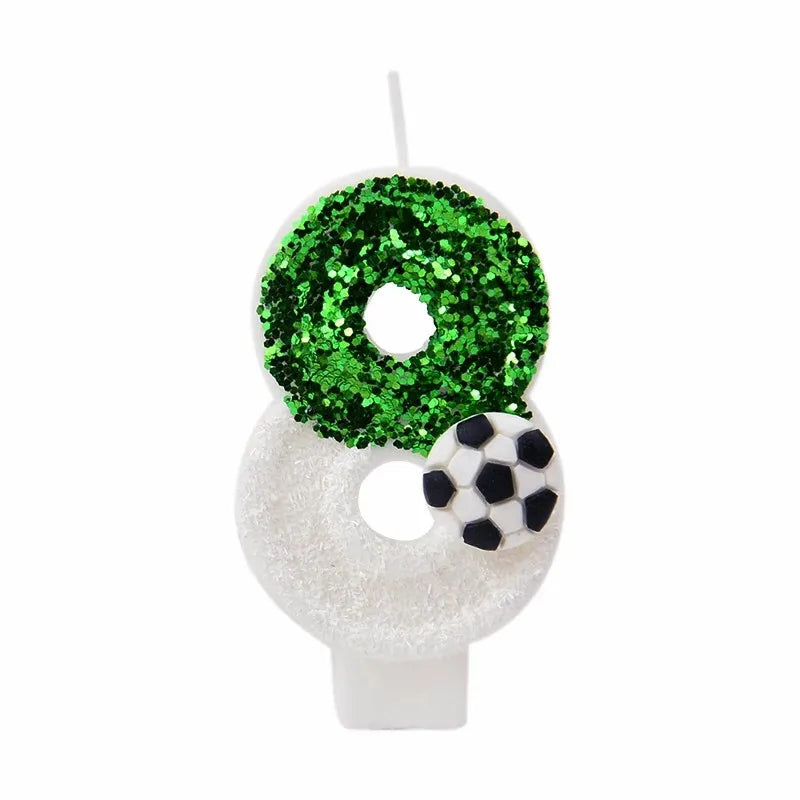 A white birthday candle decorated with a green glitter soccer ball design.