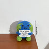 Handmade crochet potato doll with a blue and green textured body and a white tag that reads I to my love you are the world i 