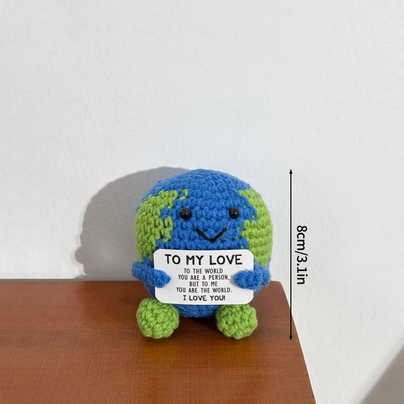 Handmade crochet potato doll with a blue and green textured body and a white tag that reads I to my love you are the world i 
