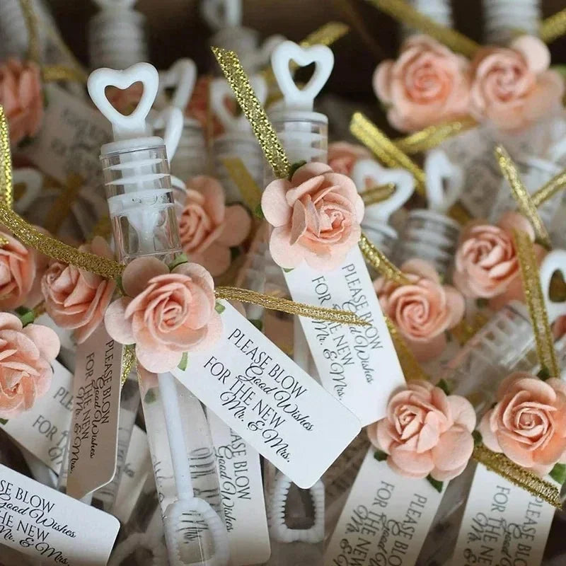A collection of heart-shaped bubble wands in white and pink roses tied with gold ribbon.