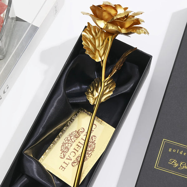 A golden metallic foil rose flower gift set with a card displayed in a black box.