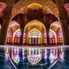 Interior view of an Islamic mosque with intricate dome architecture and colorful stained glass windows.