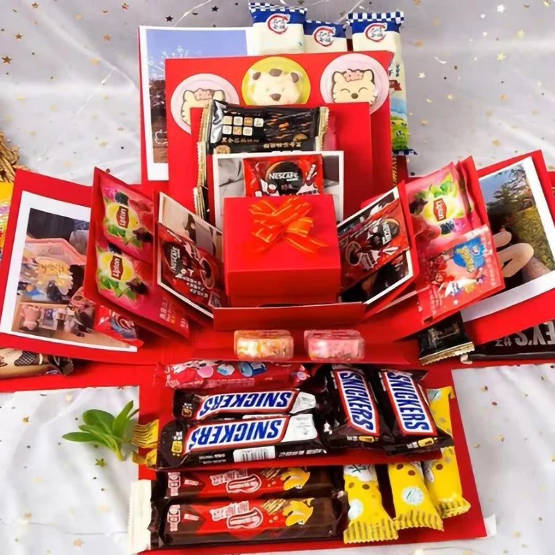 A red gift box filled with various snacks and candies is displayed on a white surface.