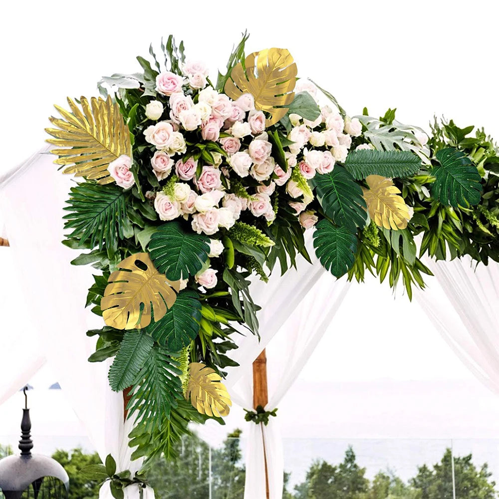 A lush floral arrangement featuring pink and white roses accented with large green tropical palm leaves and gold accents for 