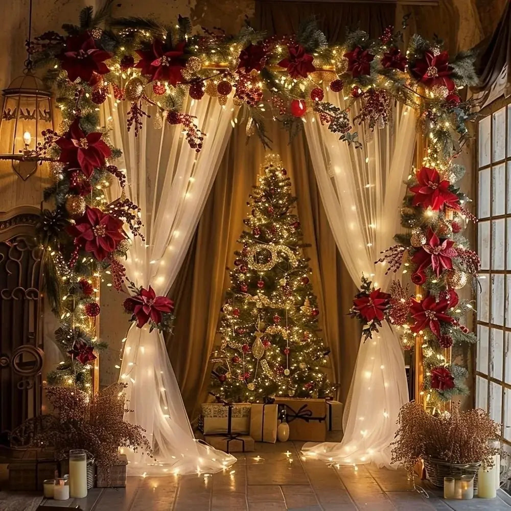 An elegant wedding backdrop featuring a large Christmas tree decorated with string lights and red floral garlands.
