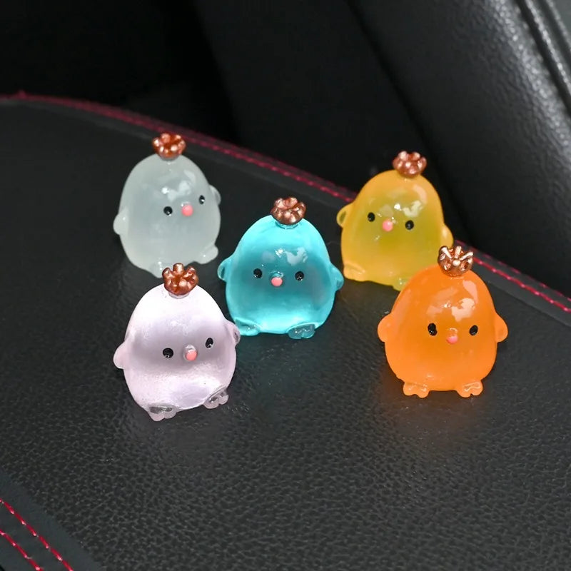 A collection of luminous resin chicken car ornaments in pastel colors including white, light blue, yellow, and orange.