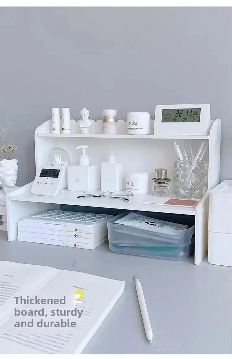 A white two-layer desktop organizer shelf displaying various stationery and desk items.