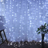 A sheer white curtain illuminated by numerous twinkling blue fairy lights creating a soft, glowing backdrop.