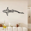 Black metal line sculpture of a shark swimming horizontally on a white wall above a sofa.