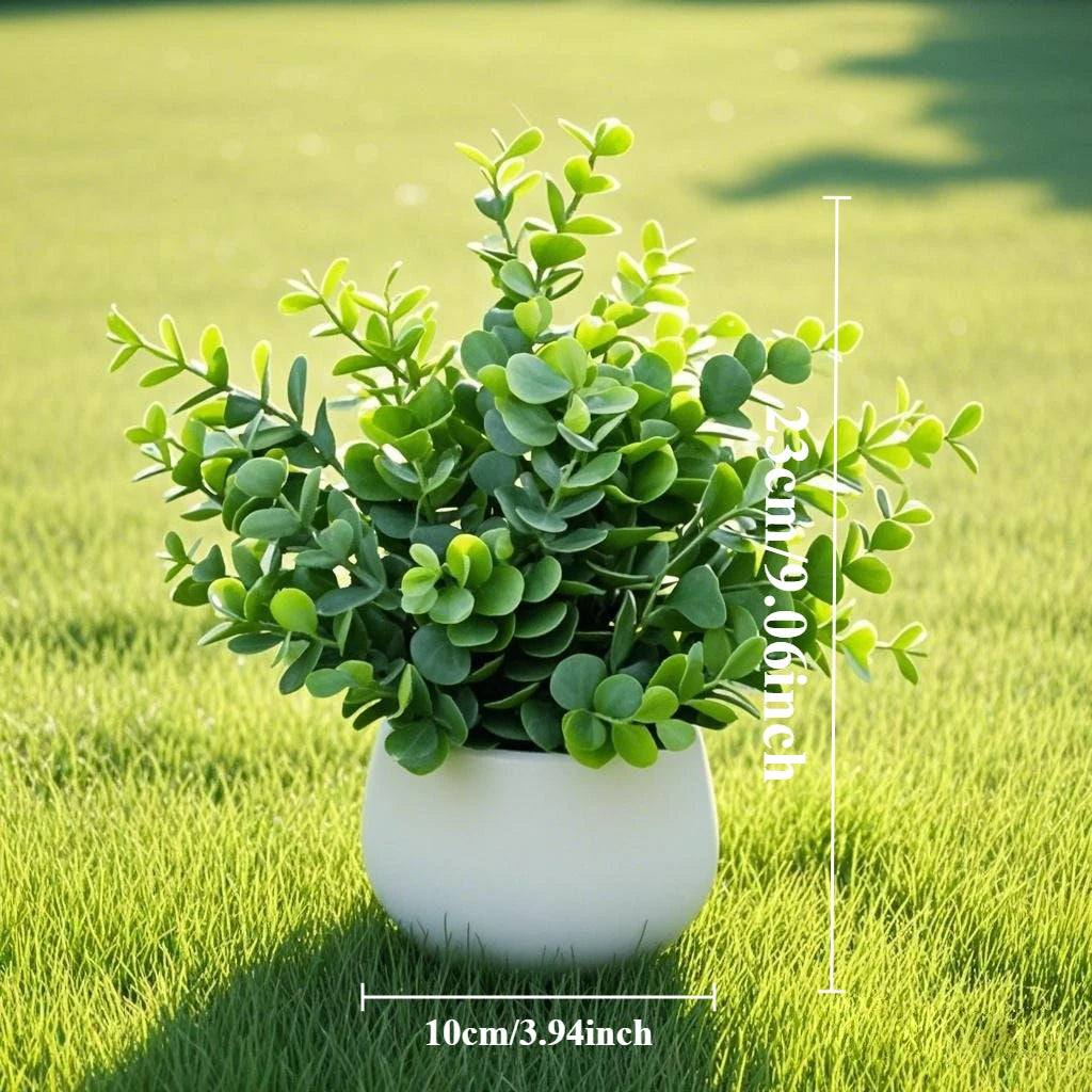 A potted artificial bonsai succulent plant with green leaves sits on a bright green lawn.