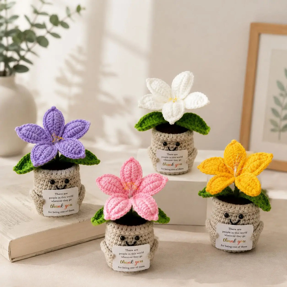 Handcrafted crochet lily flower pot with a thank you card resting on a wooden surface.
