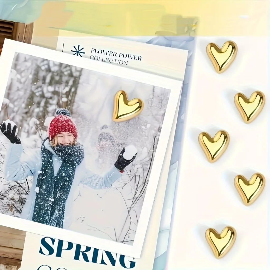 A set of gold heart fridge magnets displayed on a white background with a winter theme.