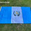 A large blue and white rectangular flag made of polyester laid out on green grass.