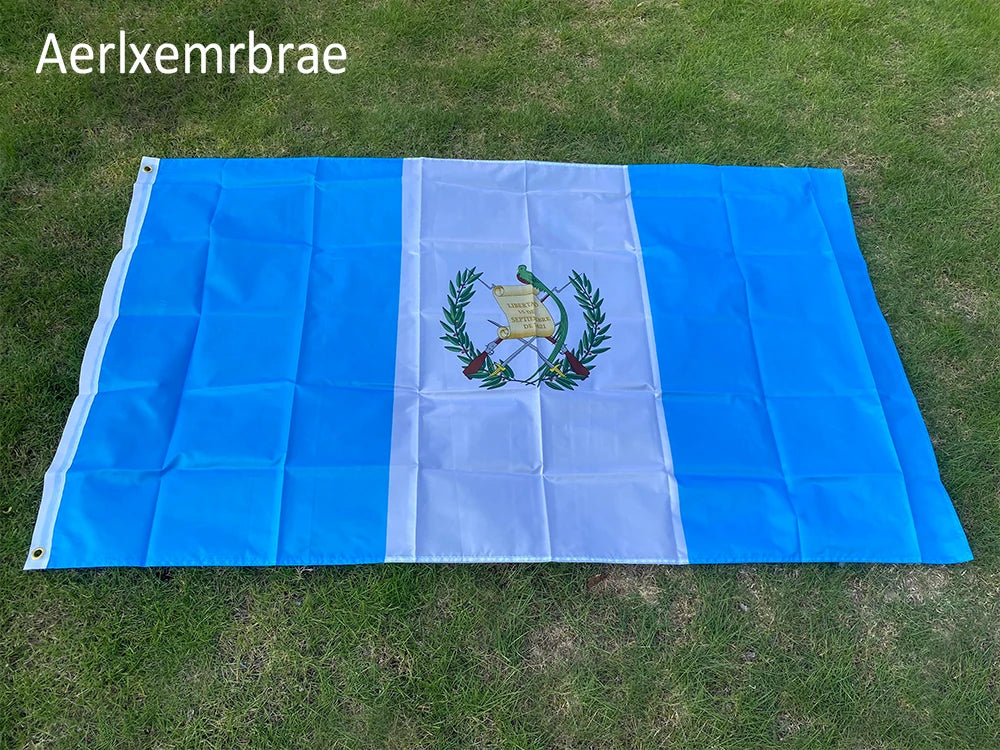A large blue and white rectangular flag made of polyester laid out on green grass.