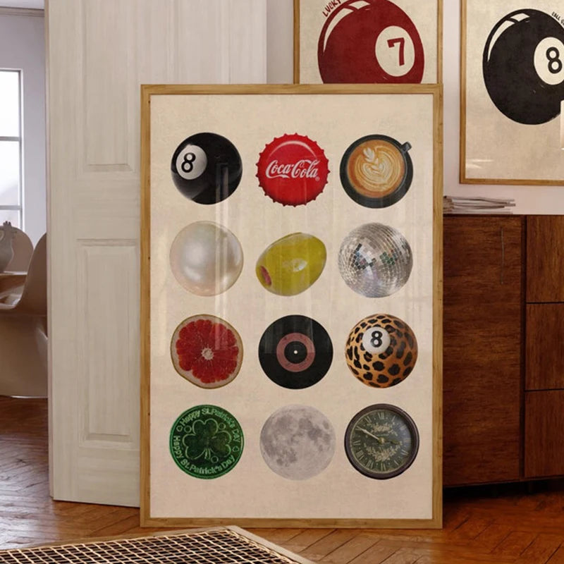 A framed collage of various spherical objects, including a Coca-Cola logo and a black 8 ball, displayed on canvas wall art.