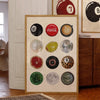 A framed collage of various spherical objects, including a Coca-Cola logo and a bowling ball, displayed as wall art.