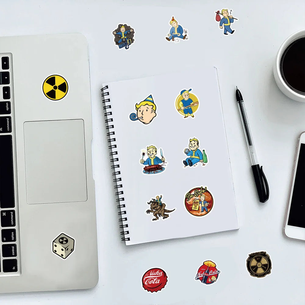 A white laptop, a spiral notebook, and various colorful graffiti art stickers are arranged on a white surface.