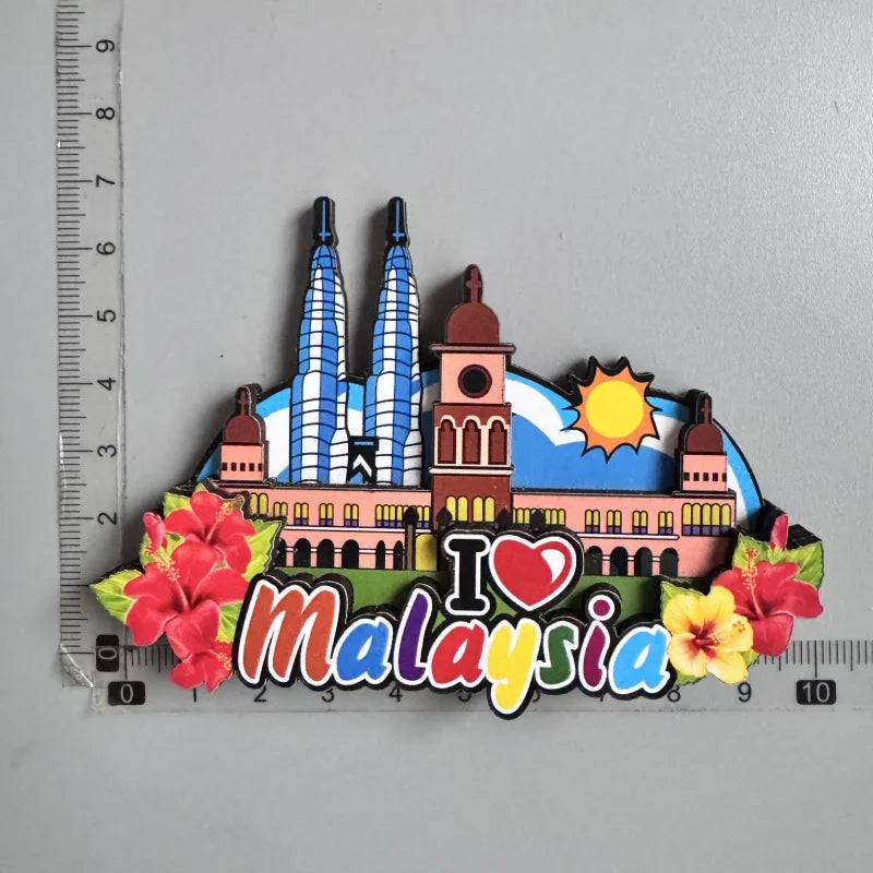 A collection of wooden fridge magnets featuring the Petronas Towers and flowers, with the text I love Malaysia.