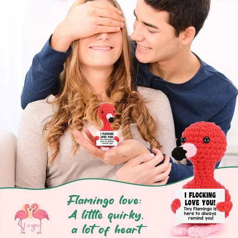 Eine Frau und ein Mann lächeln, während sie Flamingochor-Strickpuppen halten