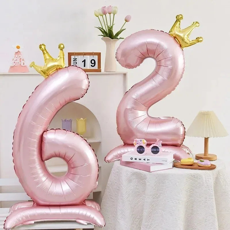 Pink foil number balloons shaped like the number 6 and a crown, used for a birthday celebration.