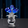 A crystal rose decorative flower arrangement featuring blue glass roses on a silver stem and clear base.