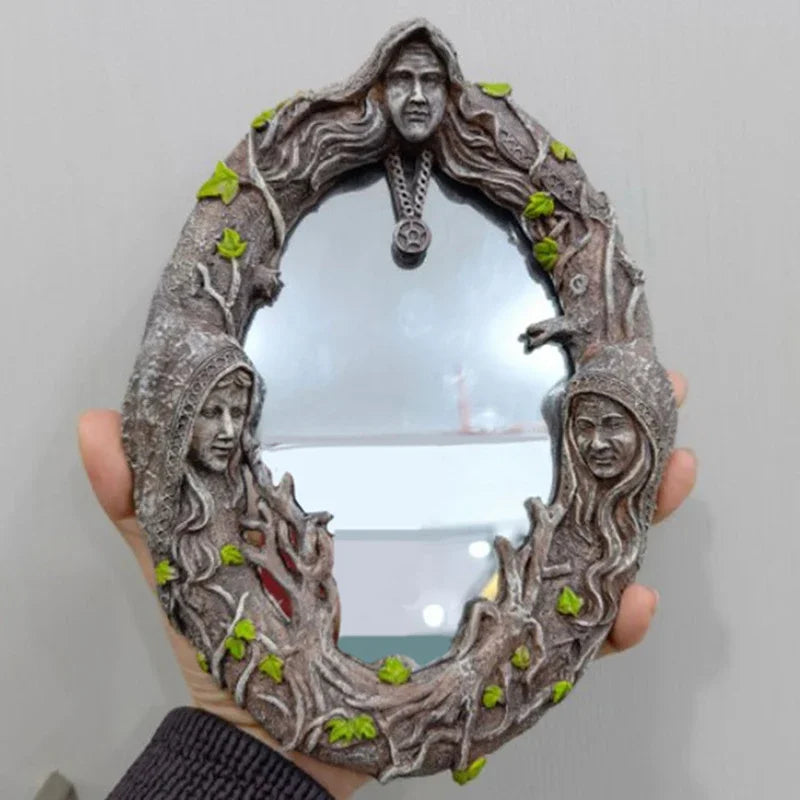 A rustic wall hanging mirror framed by branches and featuring a pentagram amulet.