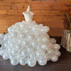 A large cluster of white pearl latex balloons forming a dome shape with a crown topper.