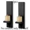 A pair of black wooden wall candle holders, each with one shelf for a candle.