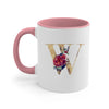 A pink ceramic coffee mug featuring a gold letter W decorated with colorful flowers and greenery.