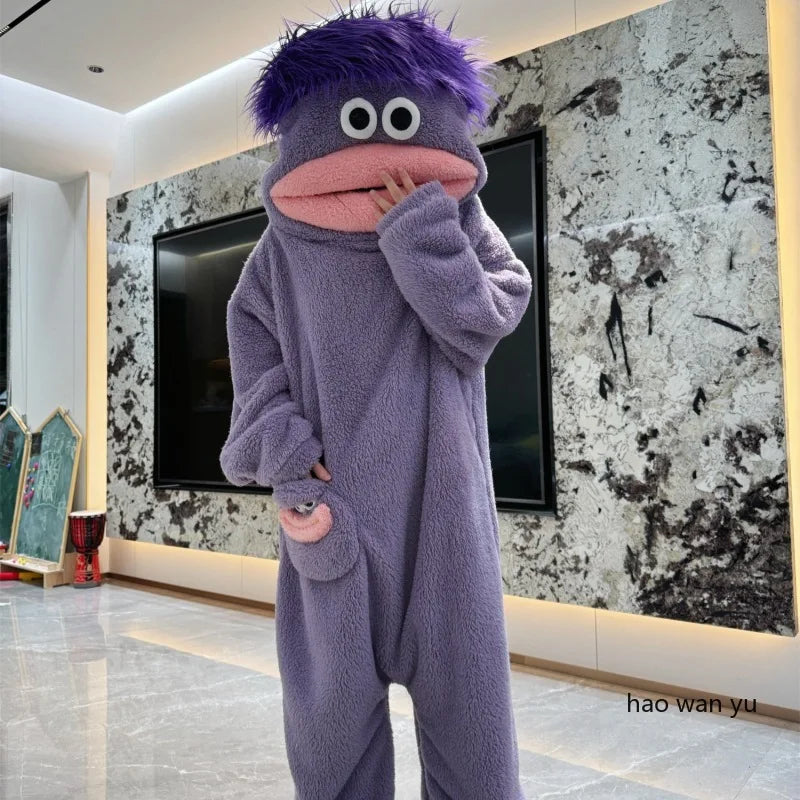 A purple coral fleece hooded sleepsuit resembling a monster with large eyes and a pink mouth.