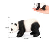 A realistic panda figurine showing a black and white coat, held in a hand for scale.