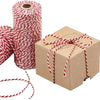 A roll of red and white twisted cotton twine next to a gift box tied with the same twine.