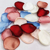 A collection of silk rose petals in shades of pink, red, blue, and white for weddings and events.