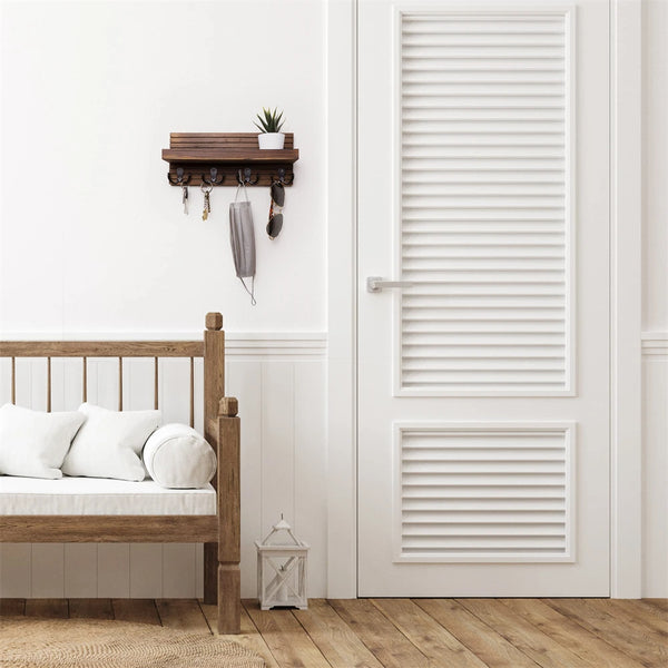 A rustic wooden key holder organizer mounted on a white wall next to a wooden bed frame.