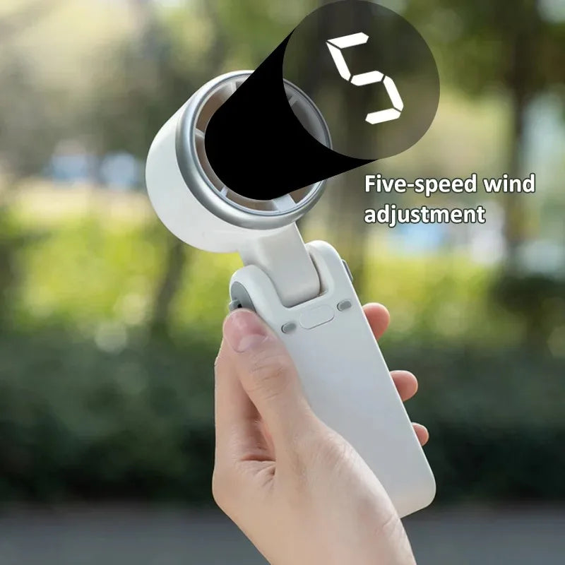 A hand holds a white foldable mini handheld fan with a five-speed wind adjustment feature.