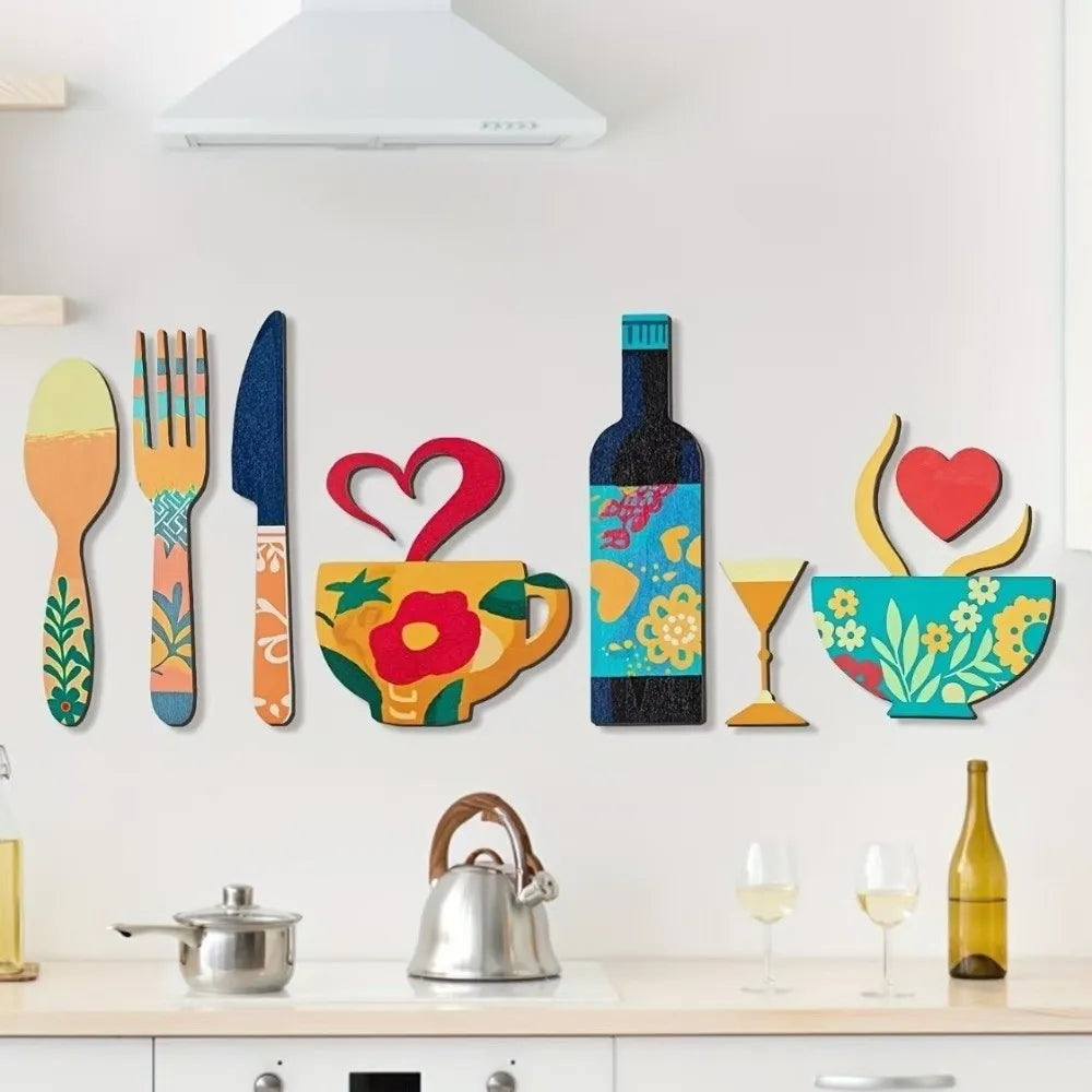 A set of rustic wood floral kitchen decor featuring a knife, fork, and teacup on a white wall.