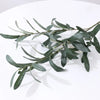 An artificial olive branch with leaves and small fruits in silk green for home and event decor.