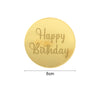 A round gold acrylic birthday topper with the text Happy Birthday engraved on it.