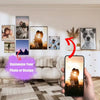 A hand holds a smartphone displaying an editing interface for customizing a photo or design, with framed photos on a wall in 
