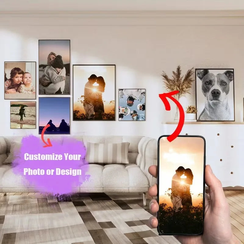 A hand holds a smartphone displaying an editing interface for customizing a photo or design, with framed photos on a wall in 