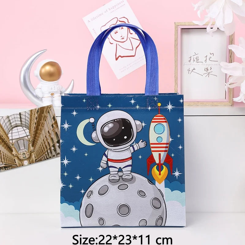 A blue tote bag featuring a cartoon astronaut on a moon surface with stars and a crescent moon design.