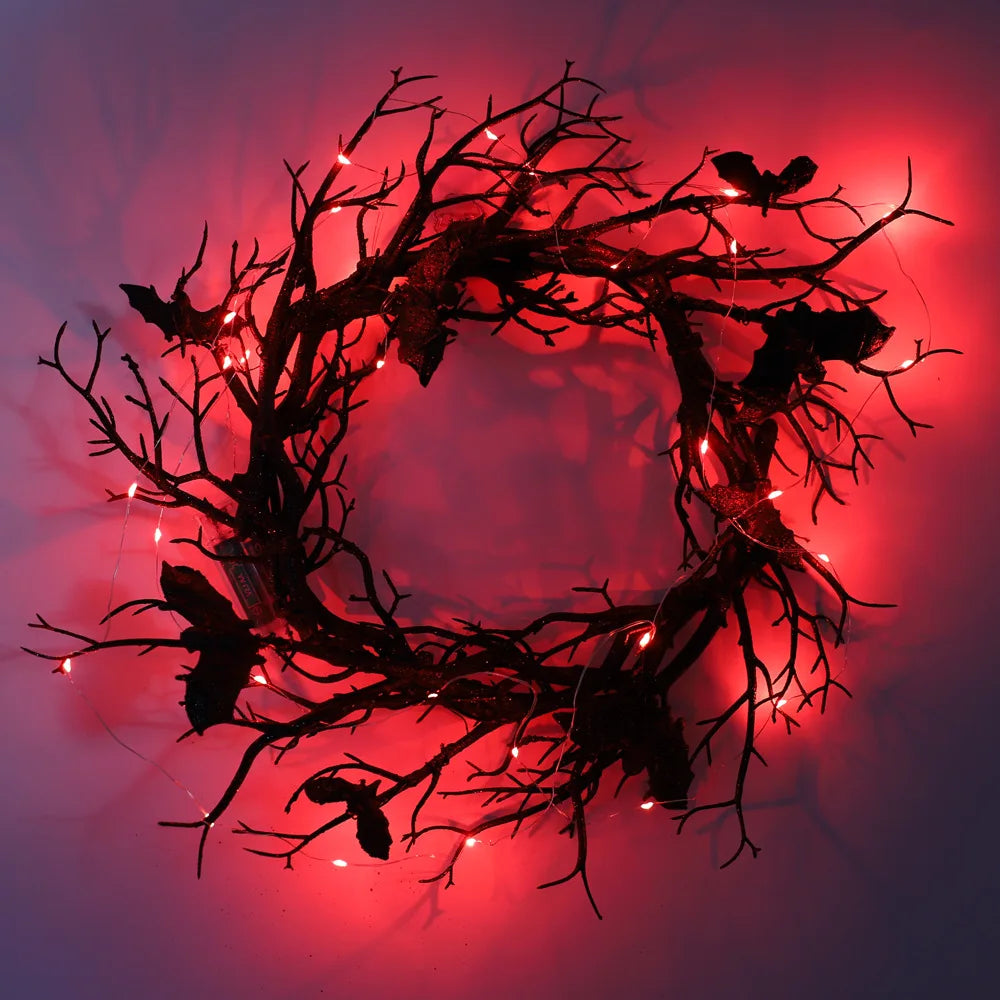 A dark, thorny branch wreath decorated with glowing lights, used for Halloween door decor.