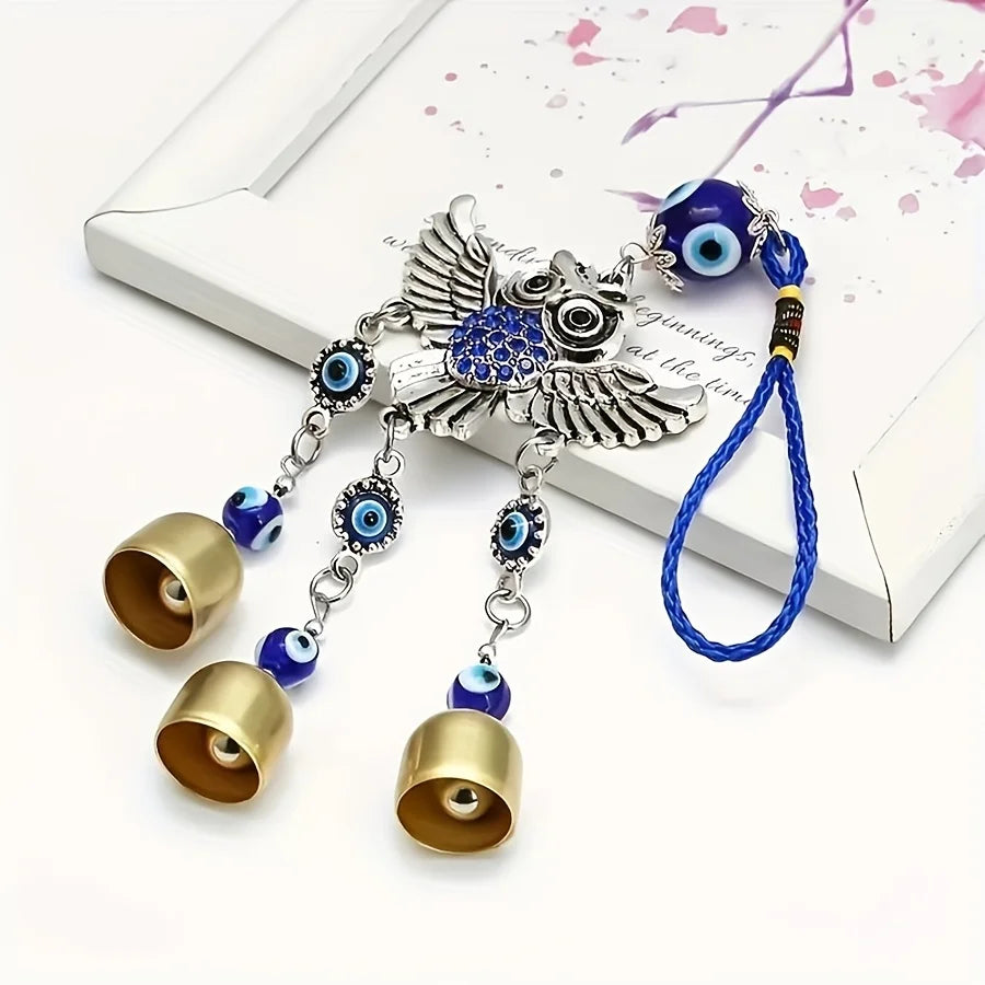 Carillon à aile d'argent avec perles bleues et dorées et un fil bleu sur fond blanc