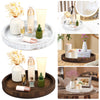 A round wooden serving tray holds various glass bottles, candles, and floral arrangements for vintage decor.
